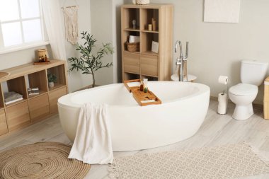 Banyonun içinde havlu, klozet ve raf ünitesi olan küvet.