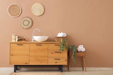 İçinde lavabo, kozmetik şişeler ve havlular olan çekmeceler.