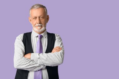 Mor arka planda şık kravatı olan yakışıklı, olgun bir adam.