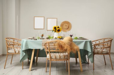 Güzel ayçiçekleri, çiçek dekoru ve mumlarla servis edilen yemek masası.