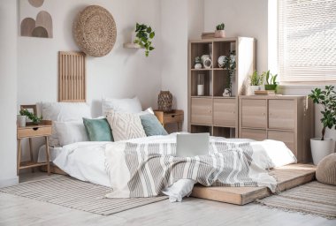 Büyük yataklı, çekmeceli ve bitkilerli yatak odasının içi.