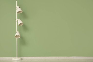 Yeşil duvarın yanındaki lamba.