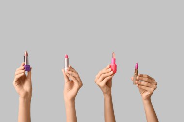 Gri arkaplanda bir sürü ruj izi olan kadın elleri.