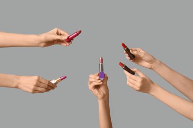 Gri arkaplanda bir sürü ruj izi olan kadın elleri.