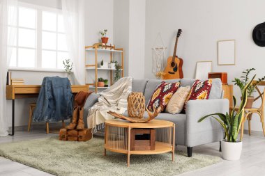 Oturma odasının içinde kanepe, kovboy şapkası ve çizmeleri var.