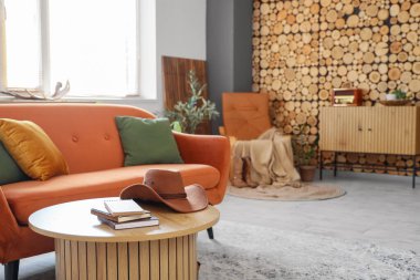 Oturma odasındaki masada kitap olan kovboy şapkası.