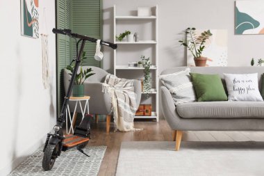 Aydınlık oturma odasının içinde elektrikli scooter.