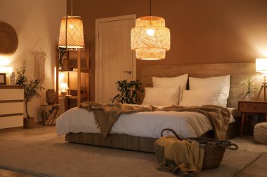 Yatak odasının içinde raf ünitesi, kapı ve geceleri parlayan lambalar var.