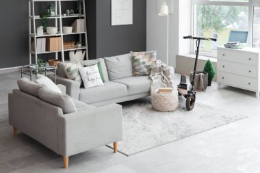 Elektrikli scooterlı ve kanepeli oturma odasının içi.