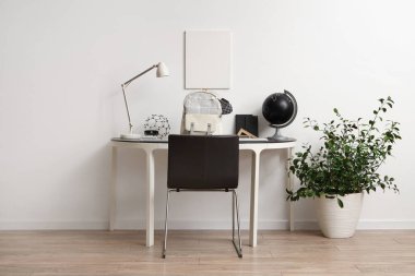 Okul gereçleri ve beyaz duvarın yanında sırt çantası olan çalışma alanı