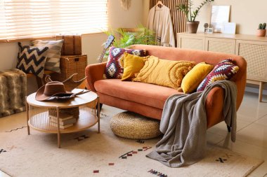 Oturma odasının içinde kanepe, kovboy şapkası ve geyik boynuzu var.