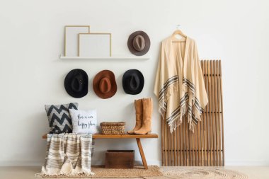 Odanın içinde ahşap bank, katlanmış perde ve kovboy şapkaları var.