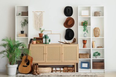 Oturma odasında çekmeceler, raf üniteleri ve kovboy şapkaları var.