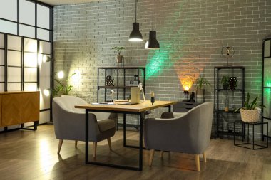 Podcaster 'ın iş yeri, raf üniteleri ve parlayan lambaları olan karanlık stüdyonun içi.