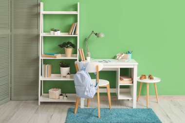 Çocuk odasında okul kırtasiyesi ve sırt çantası olan işyeri