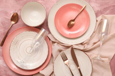 Pembe grunge arka planda güzel sofra takımı ve çatal bıçak seti
