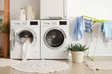 Çamaşır makineleri kurutma makinesi ve asma kurutma makinesi ev çamaşır odasının içinde.