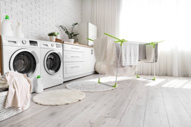 Kurutma makinesi ve çamaşır makinesi olan bir çamaşırhane.