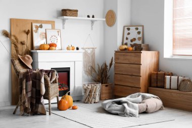 Şöminesi, koltuğu ve balkabağı olan şık bir oturma odası. Sonbahar konsepti