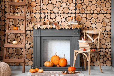 Şömineli, koltuklu ve balkabaklı bir oturma odası. Sonbahar konsepti