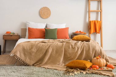 Balkabaklı ve sonbahar dekorlu rahat bir yatak odası.