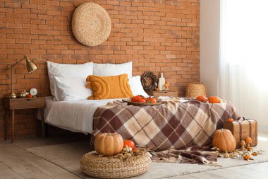 Balkabakları, bavulu ve büyük yatağı olan yatak odasının sonbaharı.