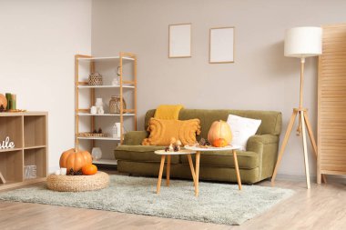 Oturma odasının sonbaharında kanepe, sehpa ve puf...