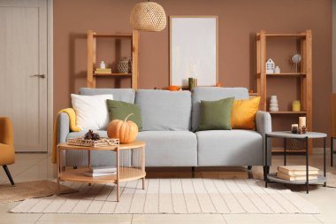 Oturma odasının sonbaharında kanepe ve dekorlu kahve masaları.