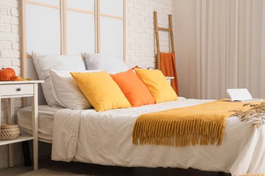 Büyük, rahat bir yatak, sonbahar dekorasyonu ve şık bir iç mekan.