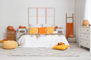 Büyük, rahat bir yatak, sonbahar dekorasyonu ve şık bir iç mekan.