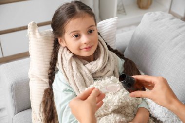 Annesi evde öksürük şurubu döken hasta küçük bir kız.