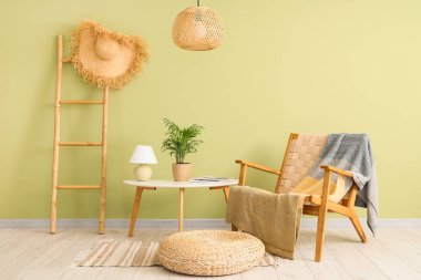 Oturma odasının içinde hasır lamba, koltuk ve masa var.