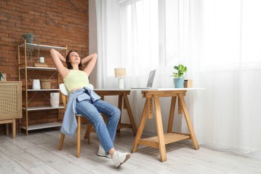 Masanın yanında oturan genç bir kadın.