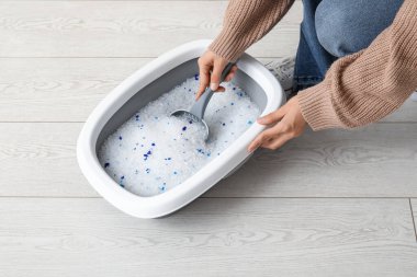 Kedi için kepçe kepçesi temizleyen kadın.
