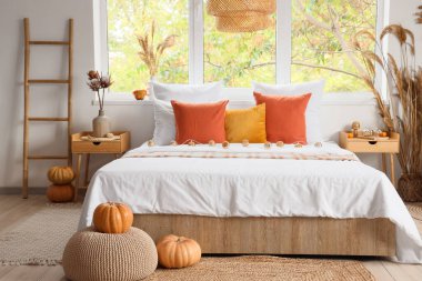 Yatak odası, yatak odası, komodin, yastık ve balkabağı.