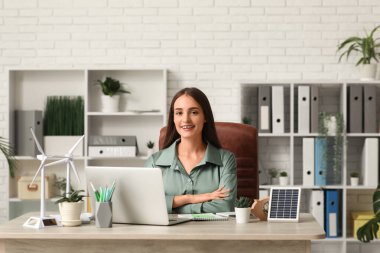 Ofisteki masasında rüzgar türbini modelleri olan kadın mühendis