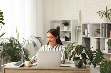 Ofiste çalışan rüzgar türbini modelli kadın mühendis.