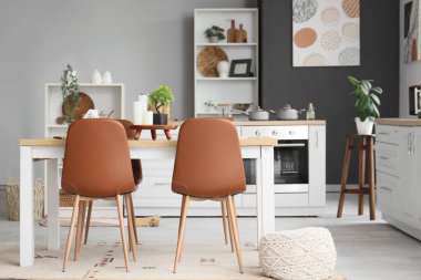 Mutfağın içinde ahşap yemek masası ve sandalyeler.