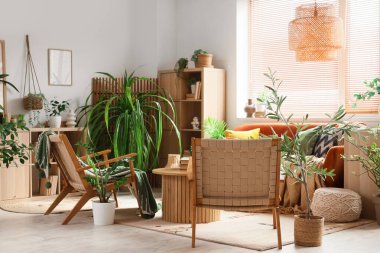 Oturma odasının içinde yeşil bitkiler var.