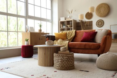 Kahverengi kanepesi, sehpası ve penceresi olan güzel bir oturma odası.