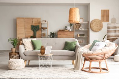 Yumuşak kanepesi, koltuğu, sehpası ve lambası olan rahat bir oturma odası.