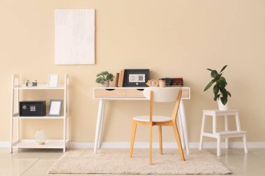 Çalışma odası, raf ünitesi ve bej duvarın yanındaki güvenli kutular.