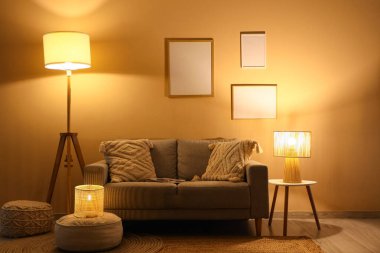 Kanepesi ve parlak lambaları olan karanlık oturma odasının içinde.