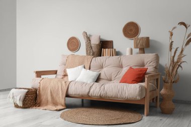 Konforlu kanepe, otlar ve salonun içinde ekoseli hasır sepet.