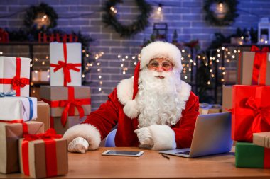 Bilgisayarlı Noel Baba, tablet bilgisayar ve hediye kutuları postanede.