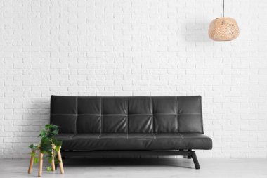 Siyah deri kanepe ve oturma odasında çiçekli kahve masası.