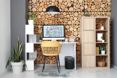 Ofis içi ahşap duvarın yanında bilgisayarı olan web tasarımcısının işyeri