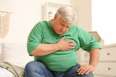 Yaşlı adam yatak odasında kalp krizi geçiriyor.