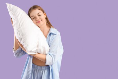 Young woman with ear plugs and pillow on lilac background clipart