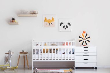 Beşik ve hayvan resimleri olan hafif çocuk odası.
